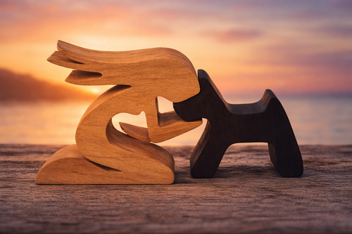 Conversational figure of a female with her pet dog against a sunset sky